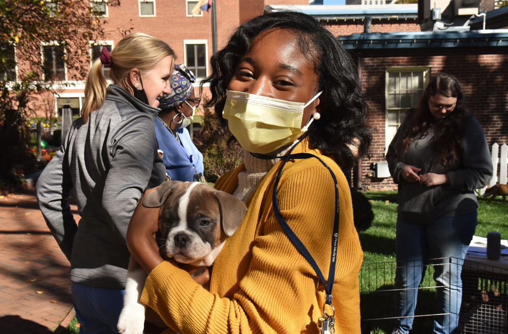 A Pennsylvania Hospital employee holds a puppy in the Elm Garden
